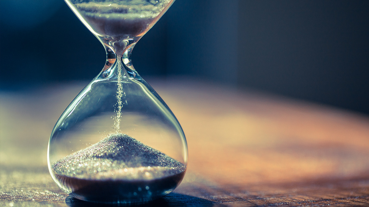 An hourglass with sand falling on dark background